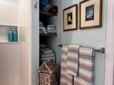 a bathroom with towels and pictures on the wall at The Artists' House Getaway in Collingwood