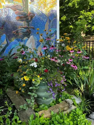 a garden with flowers in a large green vase at The Artists' House Getaway in Collingwood