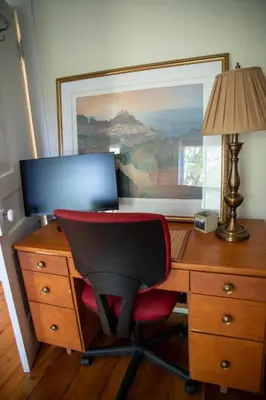 a desk with a red chair and a laptop on it at The Artists' House Getaway in Collingwood