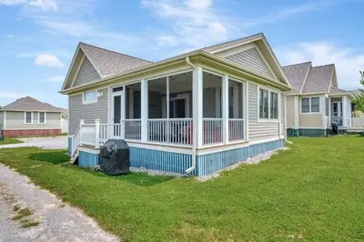 a house with a screened porch and a yard at The Osprey - 41 Butternut in Cherry Valley