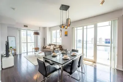a living room with a dining table and chairs at Luxury Condo with Pool, CN Tower View, Gym, Workspace in Toronto