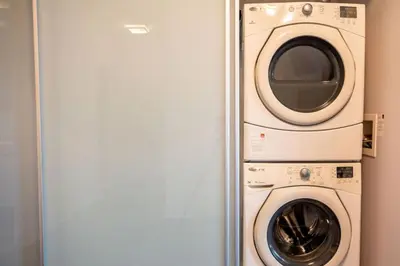 a washer and dryer sitting next to a door at Luxury Condo with Pool, CN Tower View, Gym, Workspace in Toronto