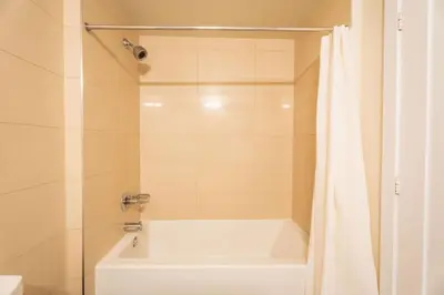 a white bath tub with a shower curtain in a bathroom at Luxury Condo with Pool, CN Tower View, Gym, Workspace in Toronto
