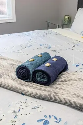 a blue towel sitting on top of a bed at Chic 3BR apartment in Queen West, Downtown Toronto in Toronto