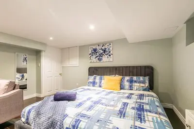 a bedroom with a bed with blue and yellow pillows at Chic 3BR apartment in Queen West, Downtown Toronto in Toronto