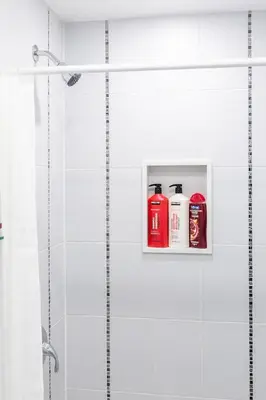 a bathroom with two shampoo bottles on a shelf at Chic 3BR apartment in Queen West, Downtown Toronto in Toronto