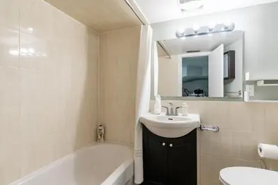 a bathroom with a sink and a toilet and a tub at Chic 3BR apartment in Queen West, Downtown Toronto in Toronto