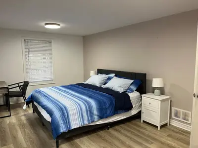 a bedroom with a bed with a blue and white comforter at Crystal Beach home in Niagara in Fort Erie