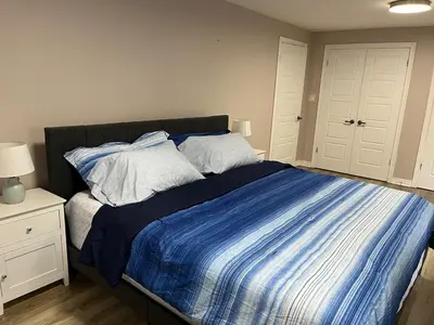 a bedroom with a bed with blue and white sheets at Crystal Beach home in Niagara in Fort Erie