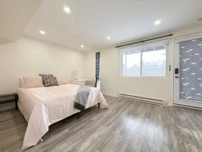a bedroom with a bed and a large window at Cozy room with private bath near Don Mills Subway in Toronto