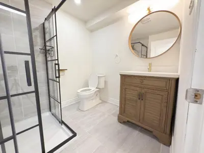 a bathroom with a toilet and a sink and a mirror at Cozy room with private bath near Don Mills Subway in Toronto