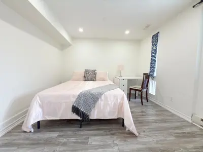 a white bedroom with a bed and a desk at Cozy room with private bath near Don Mills Subway in Toronto