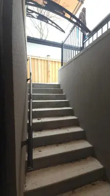 a stairway leading up to a building with a railing at Spacious Bright 9ft Ceiling with Private Entrance in Milton