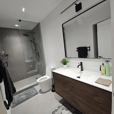 a bathroom with a sink and a toilet and a mirror at Spacious Bright 9ft Ceiling with Private Entrance in Milton