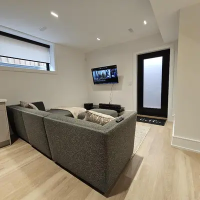 a living room with a couch and a flat screen tv at Spacious Bright 9ft Ceiling with Private Entrance in Milton
