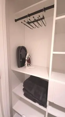 a walk in closet with white shelves and towels at Spacious Bright 9ft Ceiling with Private Entrance in Milton