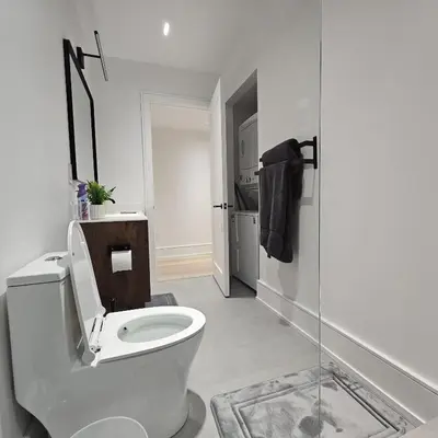 a white bathroom with a toilet and a shower at Spacious Bright 9ft Ceiling with Private Entrance in Milton