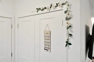 a white door with flowers and a sign on it at NEW Stylish 2BR Suite With Sofa Bed, 7 Mins to Niagara Falls and Sleeps 6 in Niagara Falls