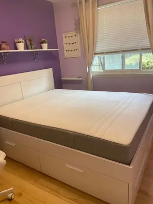 a bed in a bedroom with a purple wall at Welcoming homestay with relaxing private room in Oakville