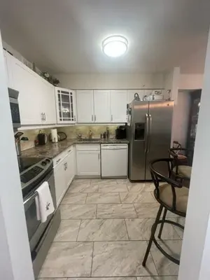 a kitchen with white cabinets and a stainless steel refrigerator at Welcoming homestay with relaxing private room in Oakville