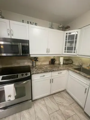 a kitchen with white cabinets and stainless steel appliances at Welcoming homestay with relaxing private room in Oakville