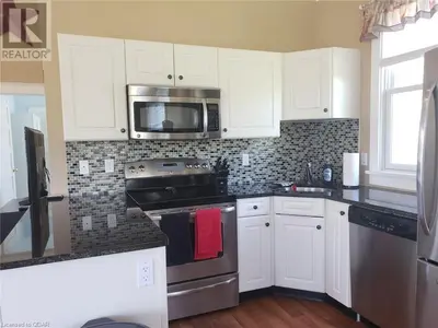 a kitchen with white cabinets and stainless steel appliances at The Clover - 91 Butternut in Cherry Valley