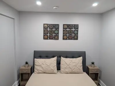 a bedroom with a large bed with two night stands at 2 Bedroom basement Apartment in Cambridge