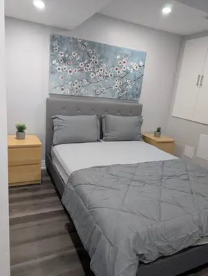 a bedroom with a bed and a painting on the wall at 2 Bedroom basement Apartment in Cambridge