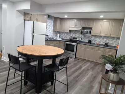 a kitchen with a table and chairs and a refrigerator at 2 Bedroom basement Apartment in Cambridge