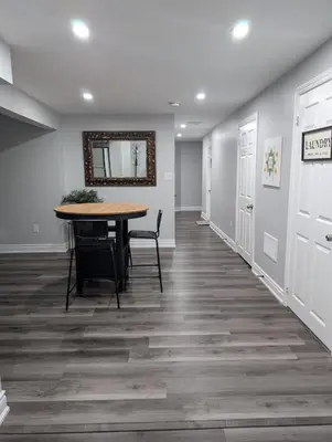a dining room with a table and a mirror on the wall at 2 Bedroom basement Apartment in Cambridge