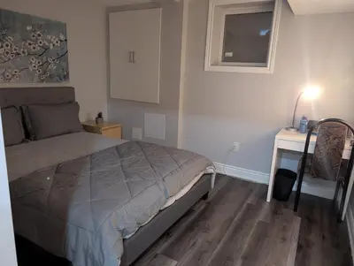 a bedroom with a bed and a desk with a lamp at 2 Bedroom basement Apartment in Cambridge