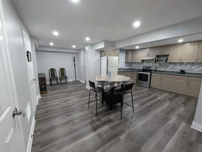 a large kitchen with a table and chairs in it at 2 Bedroom basement Apartment in Cambridge