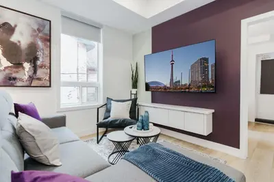 a living room with a couch and a table at The McCaul by Casa Hotels - Modern Group Suite in Toronto