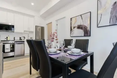 a dining room with a black table and black chairs at The McCaul by Casa Hotels - Modern Group Suite in Toronto