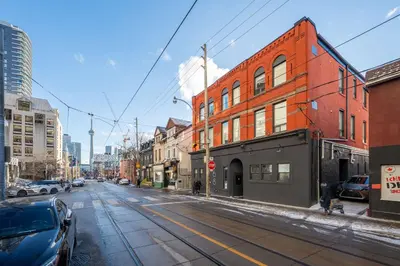 an empty city street with a red brick building at The McCaul by Casa Hotels - Modern Group Suite in Toronto