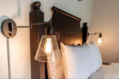 a lamp on a bed next to a pillow at Rustic Loft at Blue in Blue Mountains
