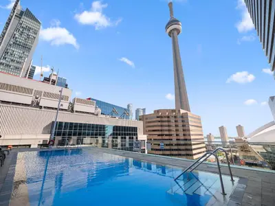 a large swimming pool with a tower in the background at Skyline Royale Penthouse - Downtown Toronto - CN Tower View, Balcony, Pool, Hot Tub in Toronto