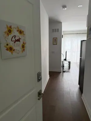 a hallway with a door with a flower picture on the wall at Brand New 2 story unit in Richmond Hill
