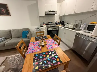 a kitchen with a wooden table with a table cloth at Brand New 2 story unit in Richmond Hill
