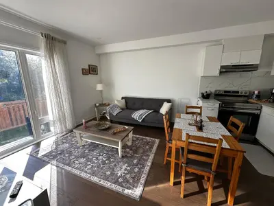 a living room with a table and a couch at Brand New 2 story unit in Richmond Hill