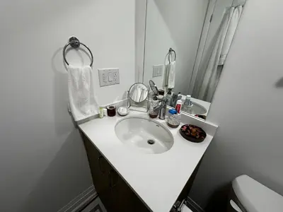 a white bathroom with a sink and a mirror at Brand New 2 story unit in Richmond Hill