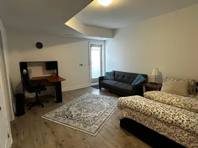 a living room with a bed and a couch and a desk at Brand New 2 story unit in Richmond Hill