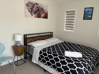 a bedroom with a bed with a black and white comforter at Whole House 4 Bedrooms 6 beds 3 bath family friendly Quite and relaxation area in Gravenhurst