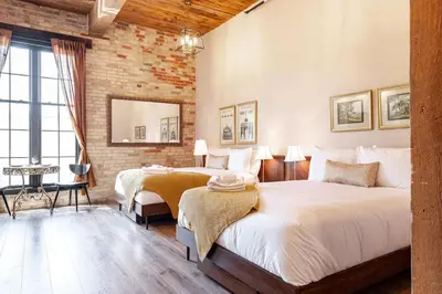 a bedroom with two beds and a brick wall at The Wallace Suite - Stratford in Stratford
