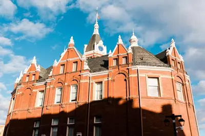 a large red brick building with a clock tower at The Wallace Suite - Stratford in Stratford