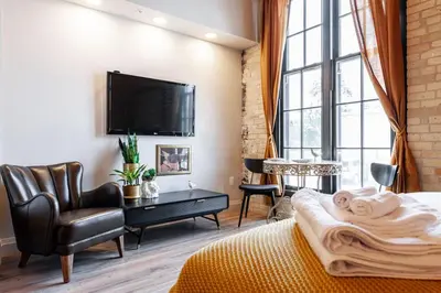 a bedroom with a bed and a tv and a chair at The Wallace Suite - Stratford in Stratford