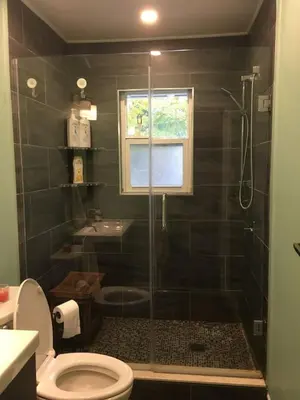 a bathroom with a shower with a toilet and a sink at Splendid Modern Bungalow Suited For Big Groups in London