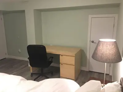 a bedroom with a desk and a chair and a lamp at Upscale 2-Bedroom Basement Apartment in London