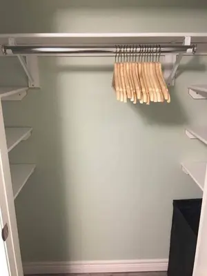 a walk in closet with white walls and shelves at Upscale 2-Bedroom Basement Apartment in London