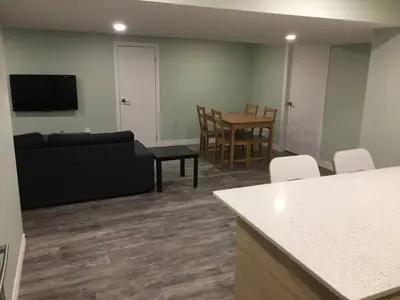 a living room with a couch and a table at Upscale 2-Bedroom Basement Apartment in London